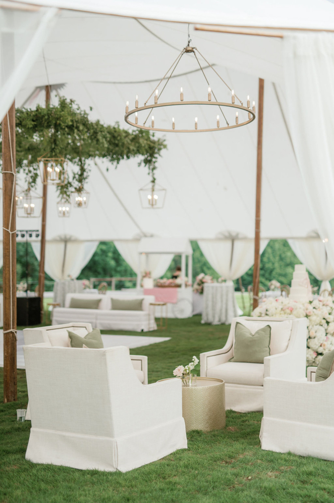 The Southern wedding reception tent has lounge furniture and and lighting.