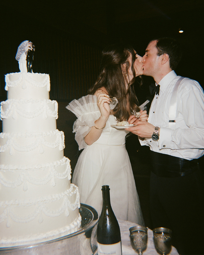 The bride and groom share a first bite of wedding cake together during their reception.