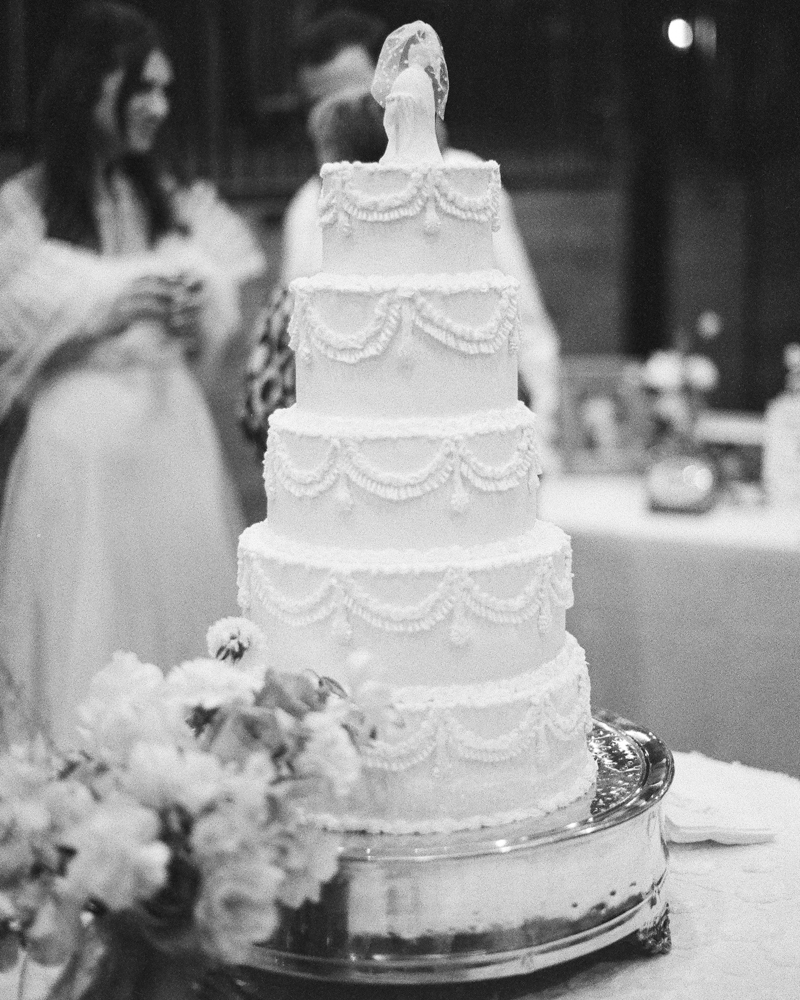 The classic wedding cake is photographed in black and white.