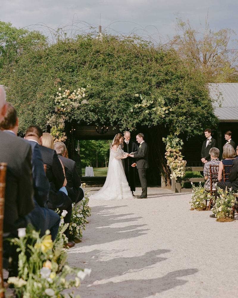 The bride and groom exchange rings during their wedding ceremony at Windwood Equestrian.