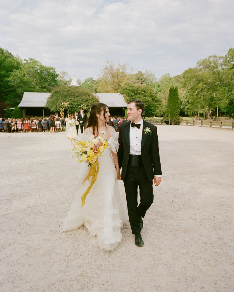 The bride and groom exit the wedding ceremony at Windwood Equestrian.