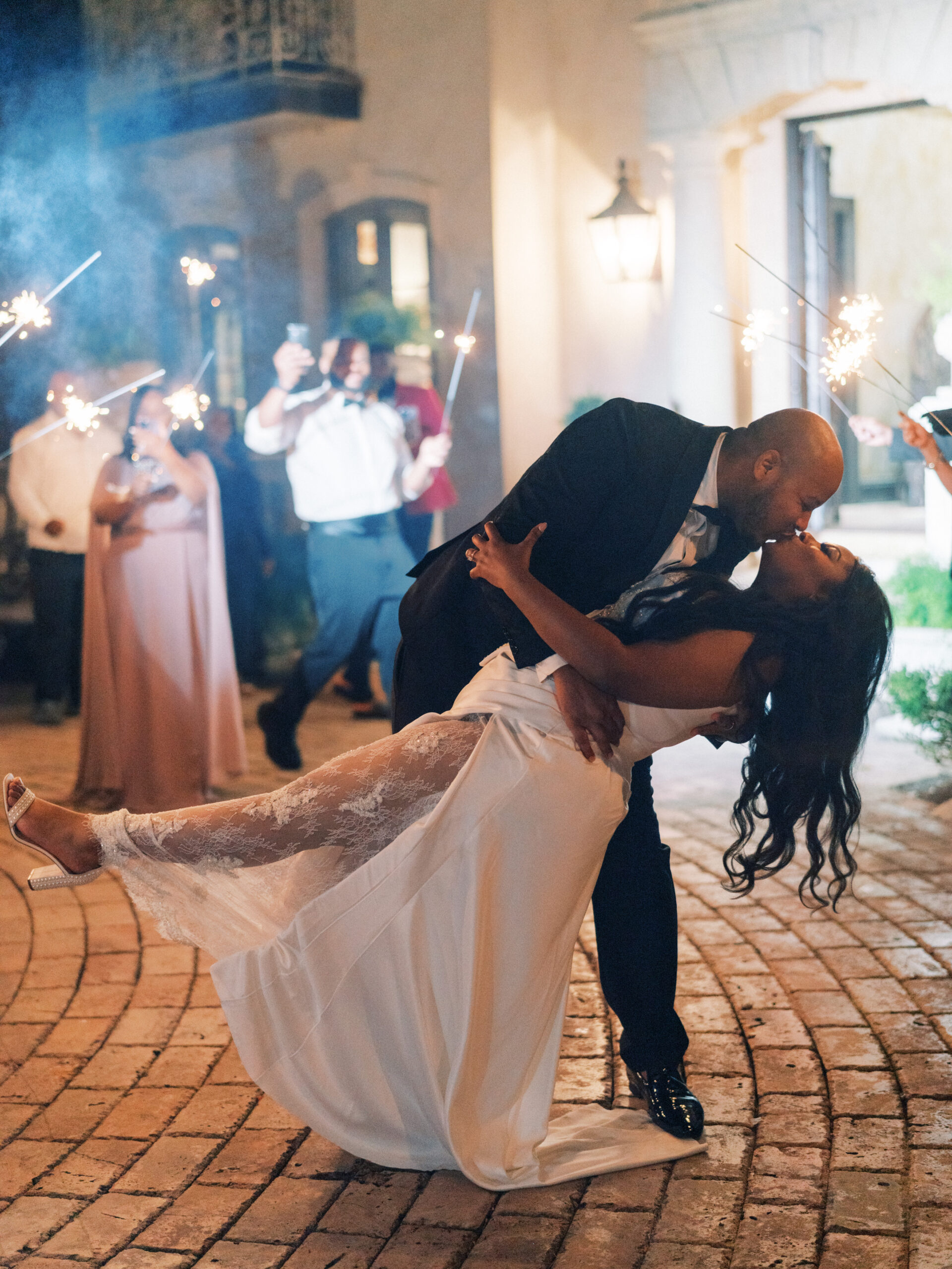 The bride and groom share a kiss at the exit their wedding reception in Alabama.