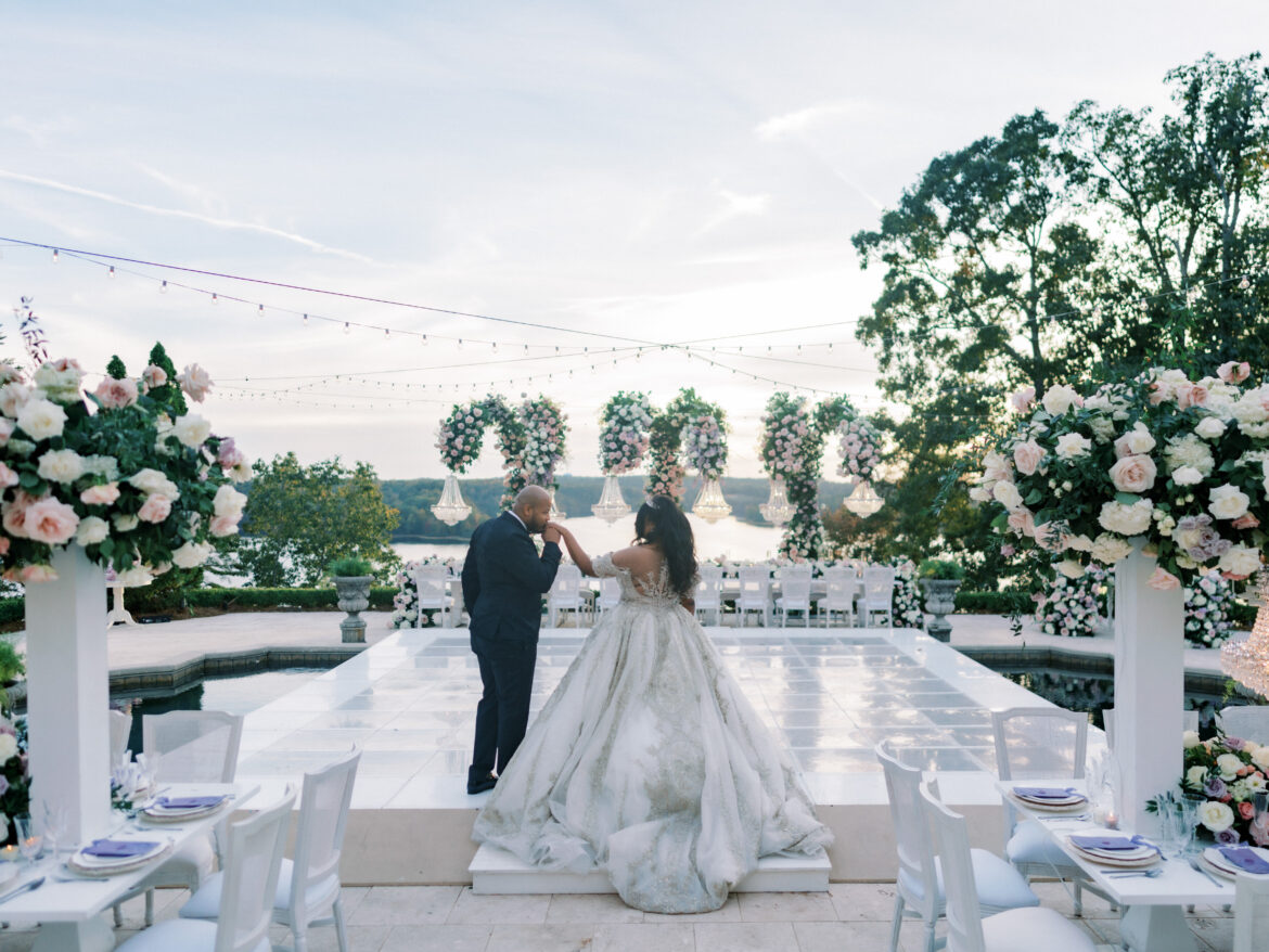 The groom kisses the bride's hand as they enter their wedding reception in Tuscaloosa, Alabama.