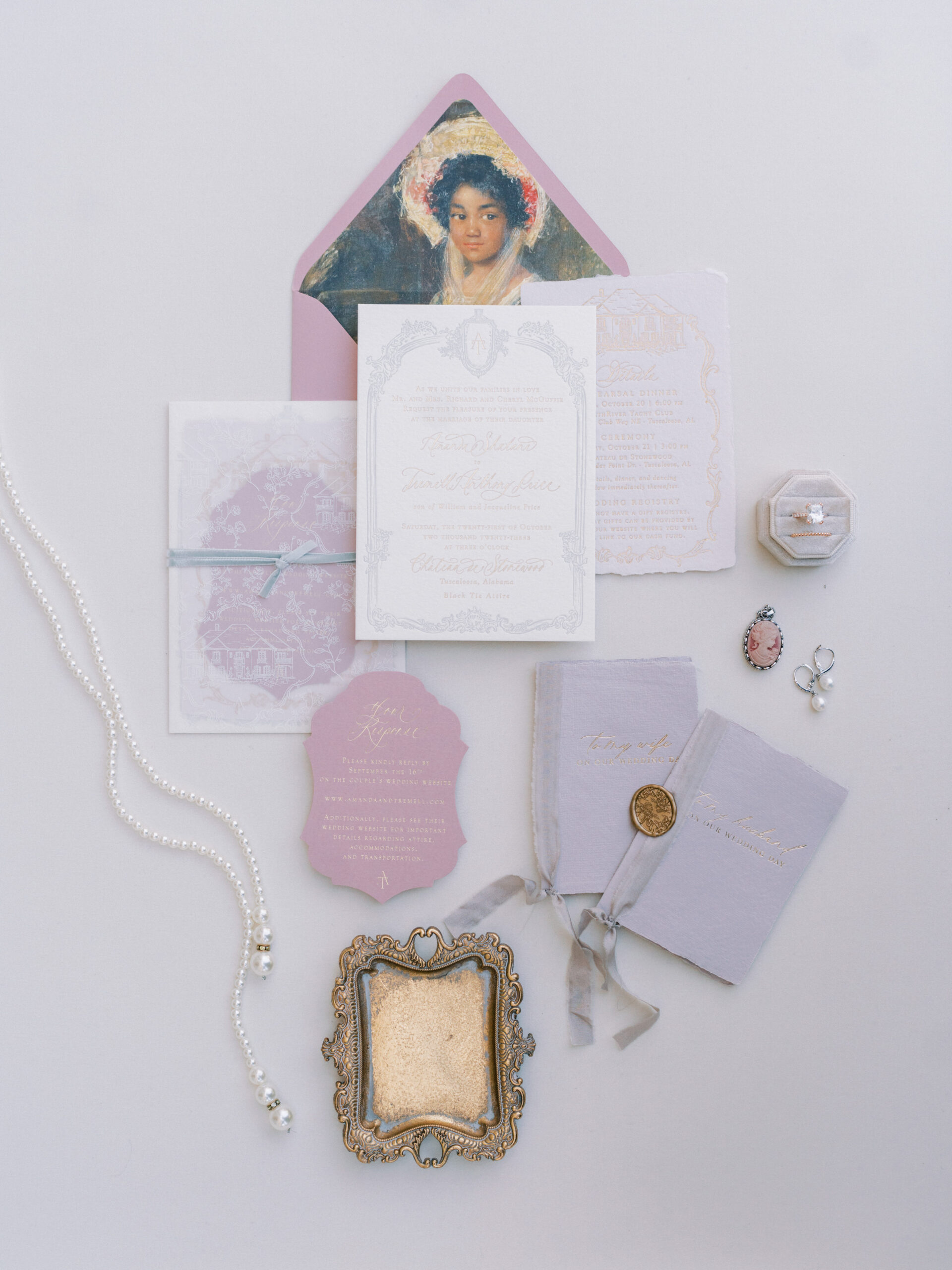 The wedding stationery is styled in a lay flat with pearls and wedding rings.