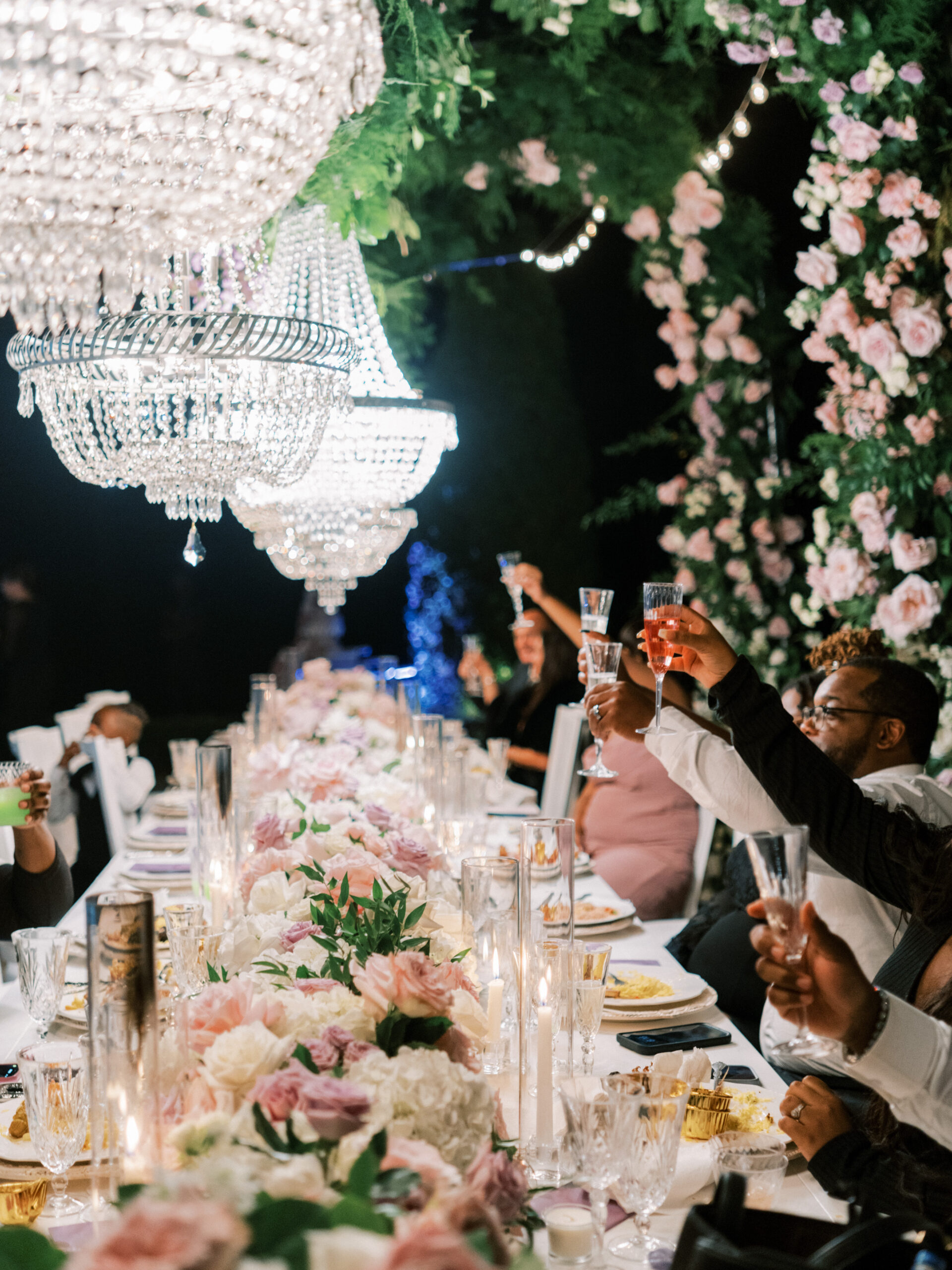 The wedding guests toast each other at the reception table under chandeliers in Tuscaloosa, Alabama.