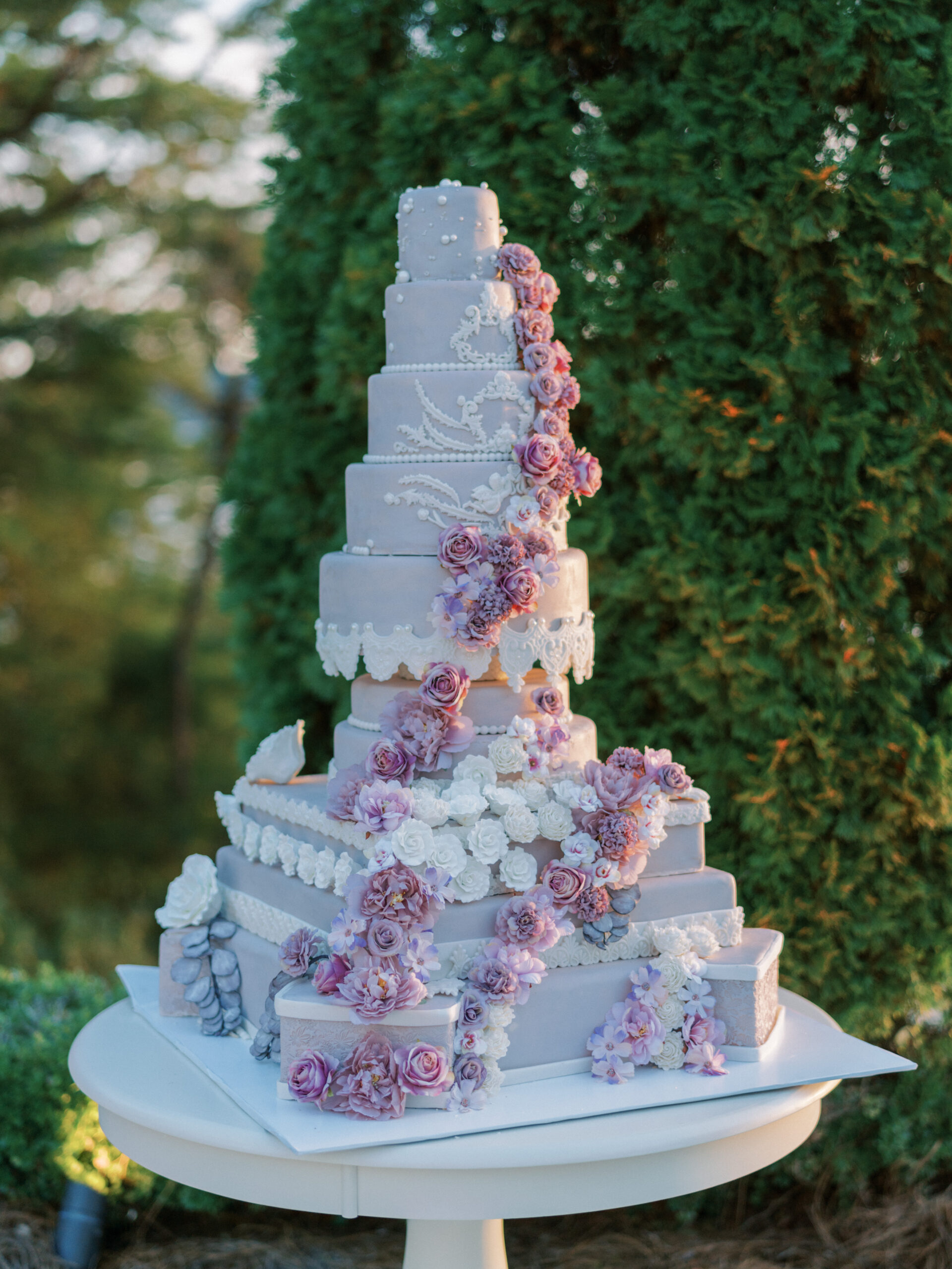 The ornate wedding cake has ten layers with purple flowers.