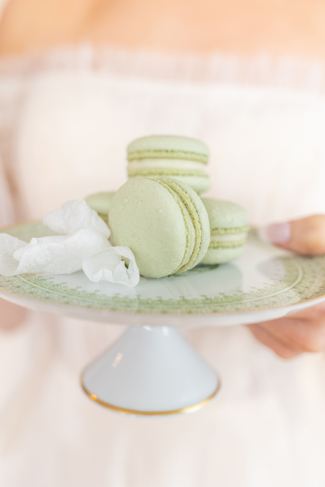 A bride holds a plate of macarons for a wedding in Alabama.