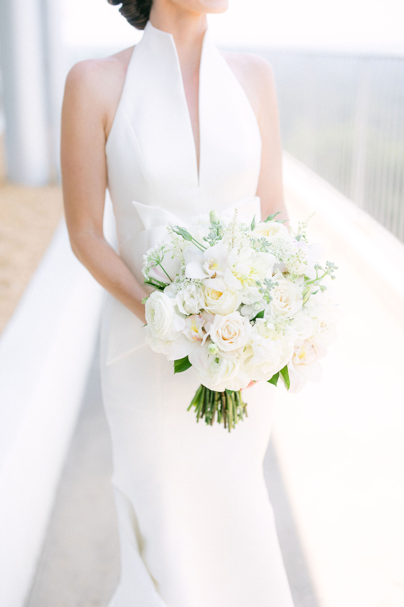 The bride holds her classic white wedding bouquet.