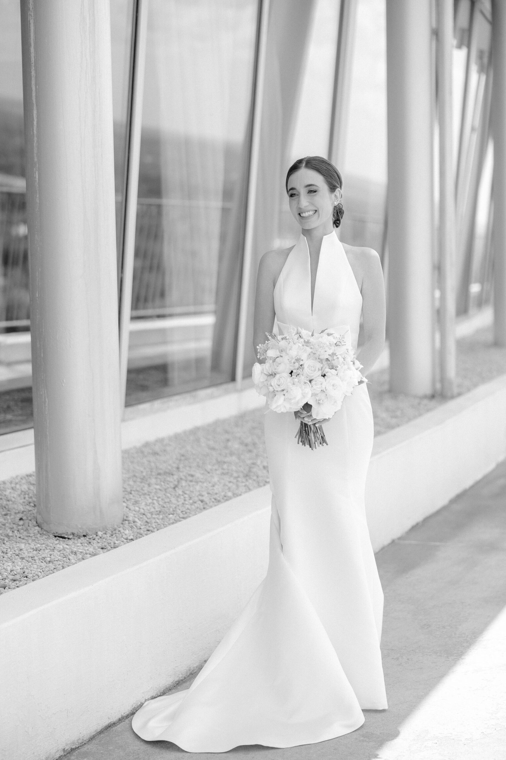 The bride holds her bouquet while wearing a wedding dress from The White Room Bridal Salon.