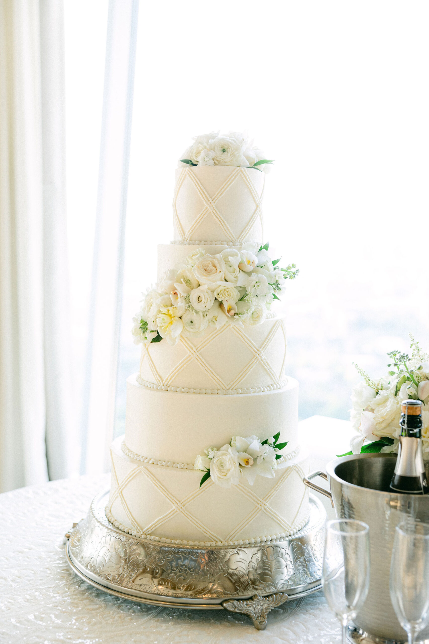 The classic white wedding cake is decorated with white flowers in Alabama.