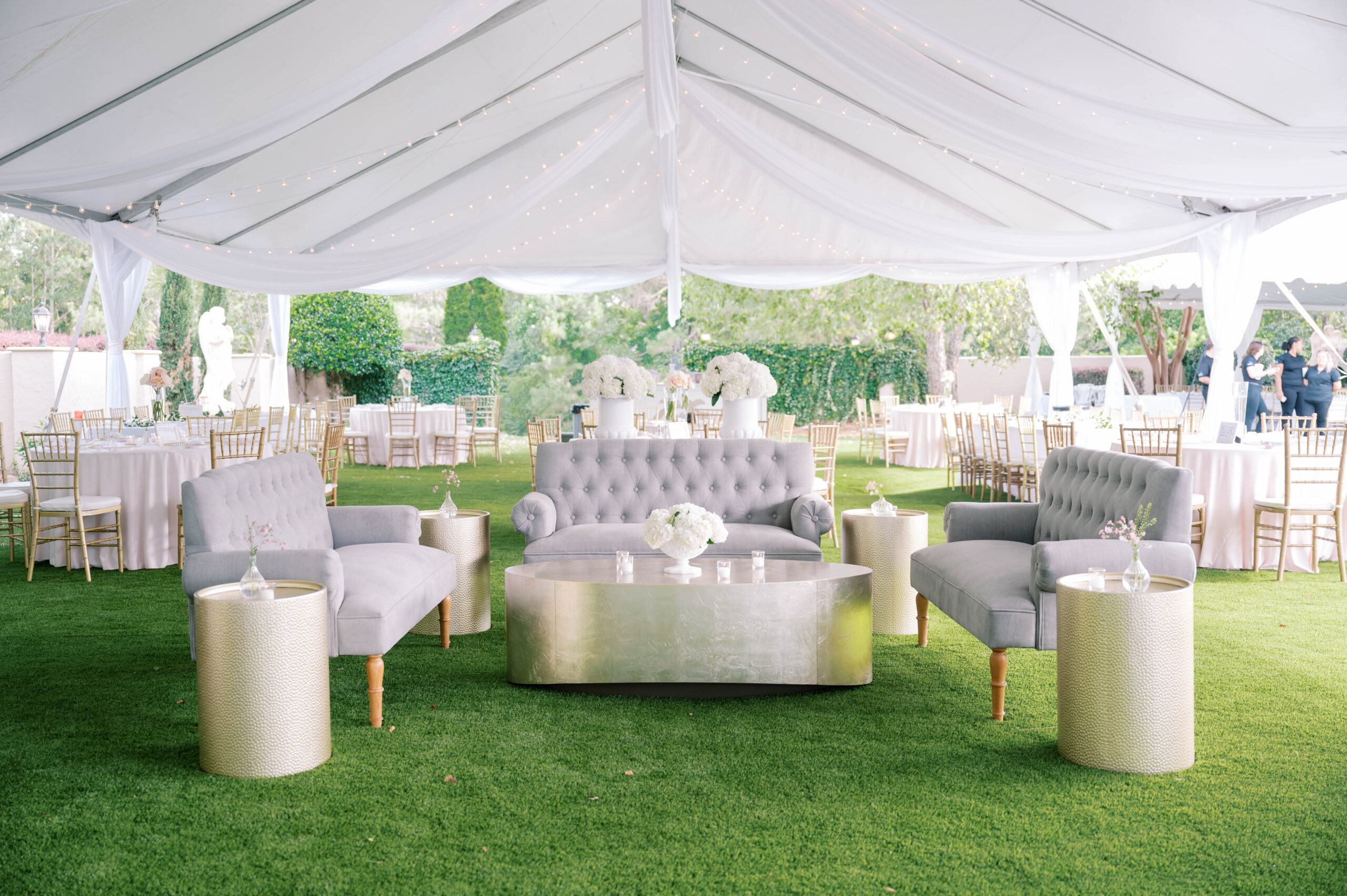 The wedding reception is held under a tent with lounge furniture at Fountainview Mansion.