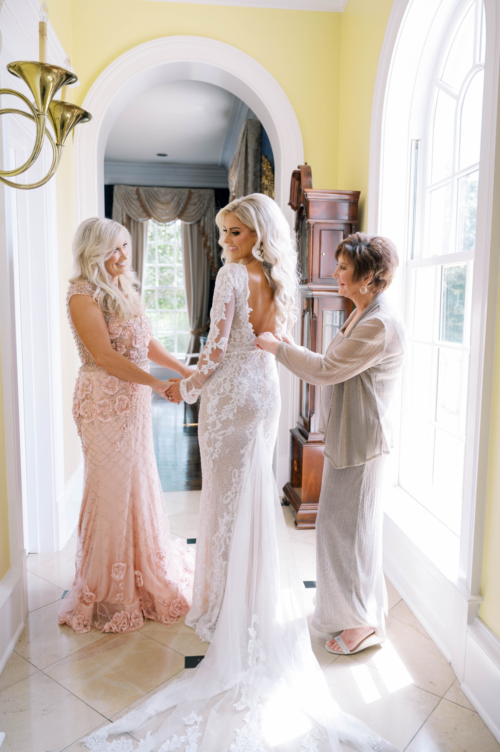 The bride puts on her wedding dress with her family in Auburn, Alabama.