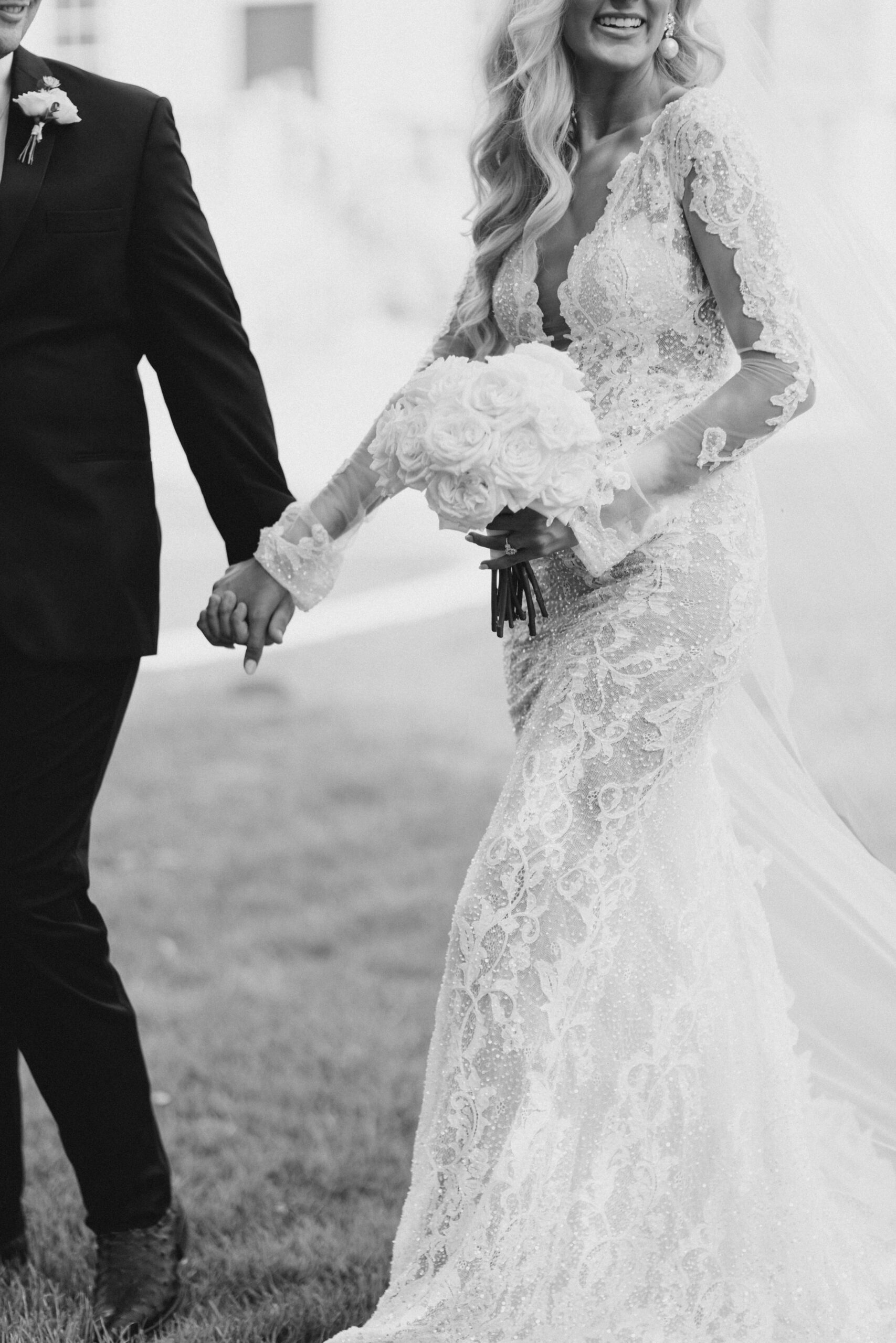 The bride is photographed in black and white holding her bouquet.