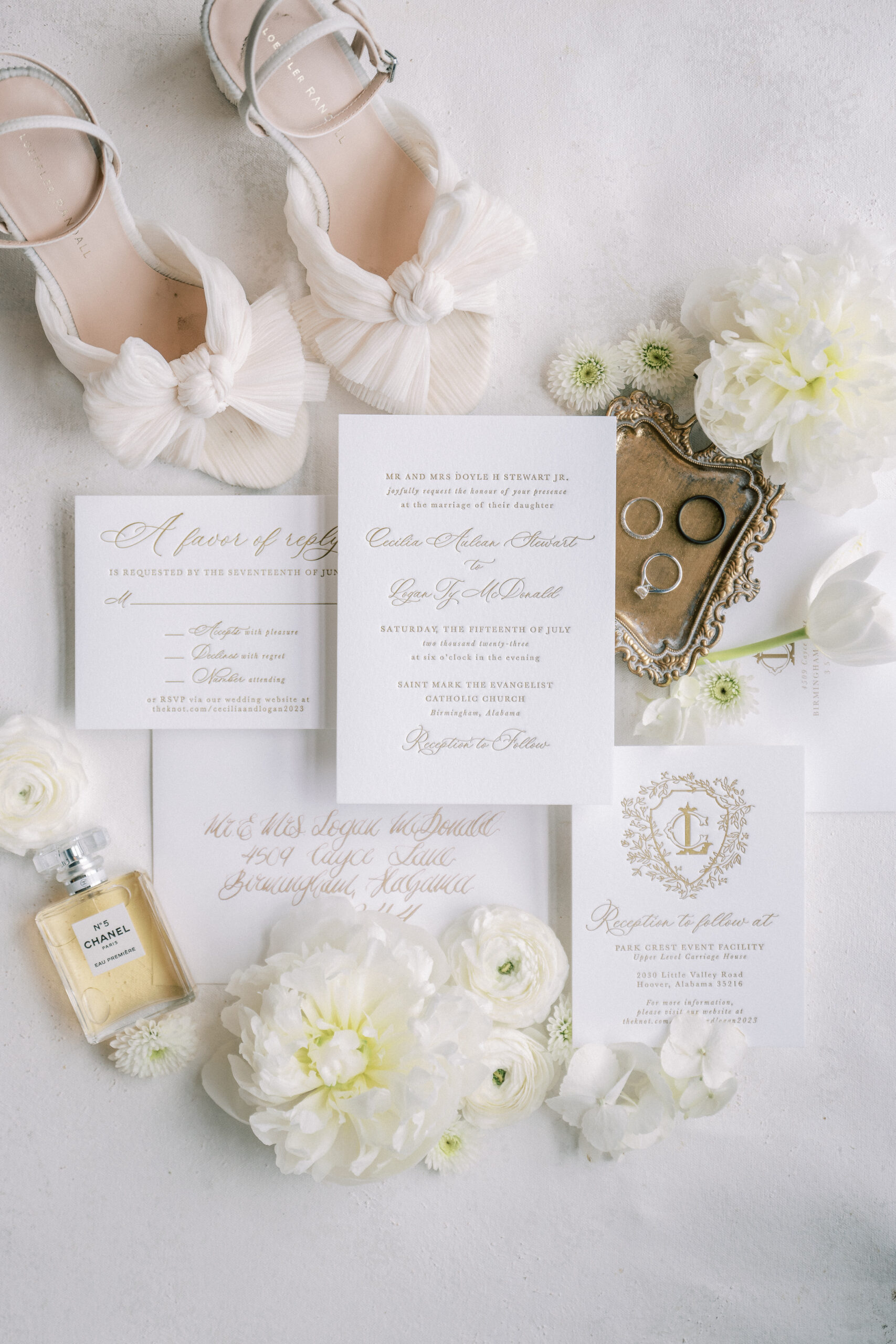 White wedding invitations are styled with the shoes and jewelry.