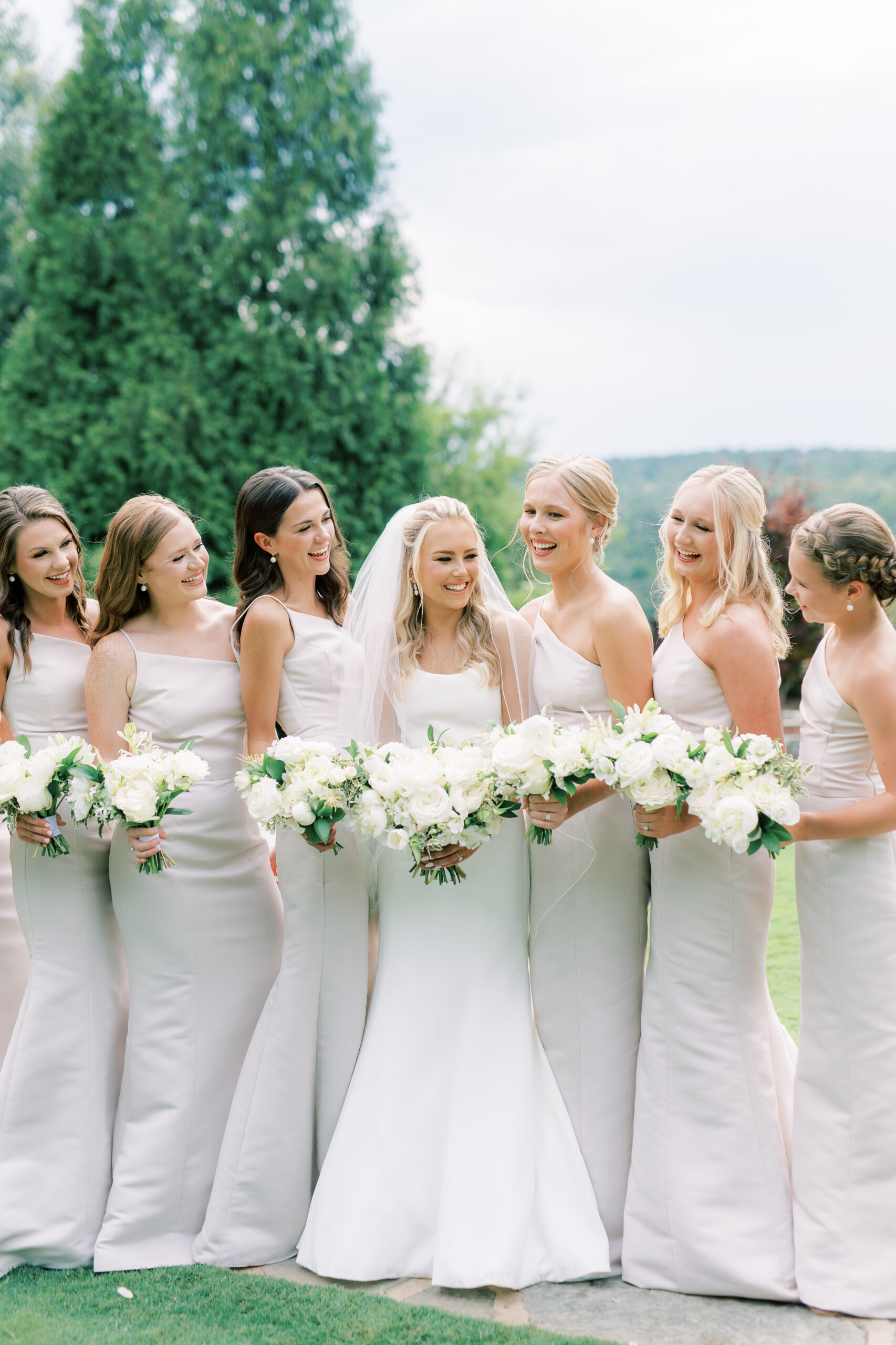 The bride smiles with her bridesmaids for a Southern wedding.