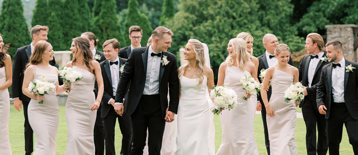 The wedding party walks together at Park Crest Event Facility.