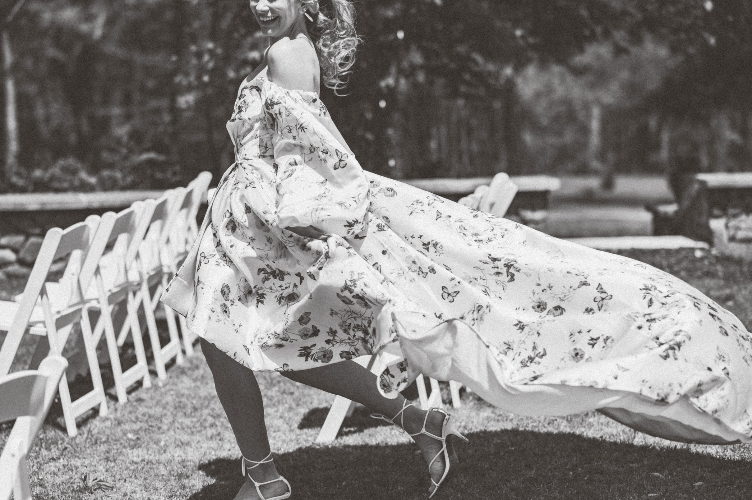 The bride runs in her floral print wedding dress.