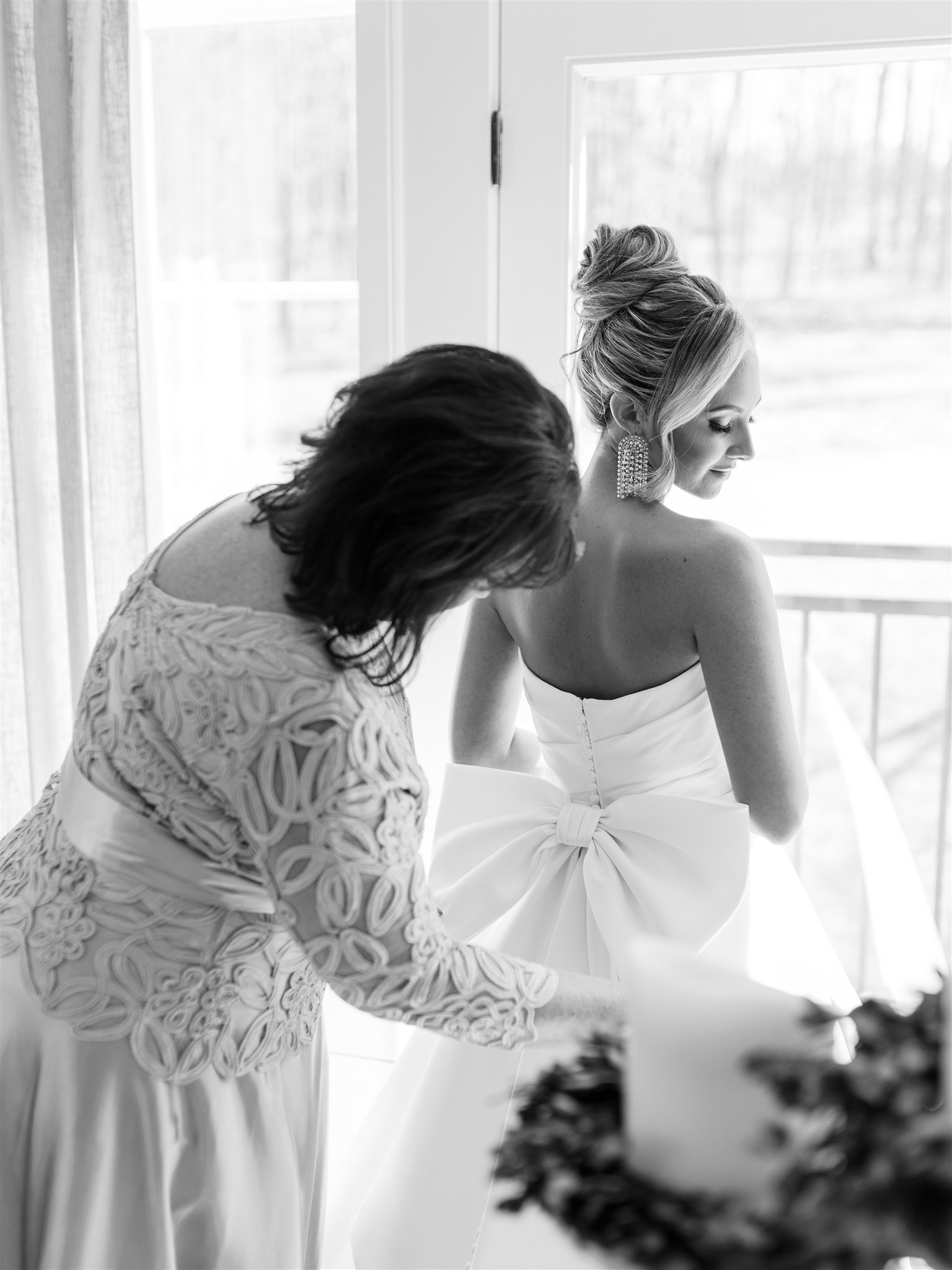 The mother of the bride helps her daughter into her wedding dress in Alabama.