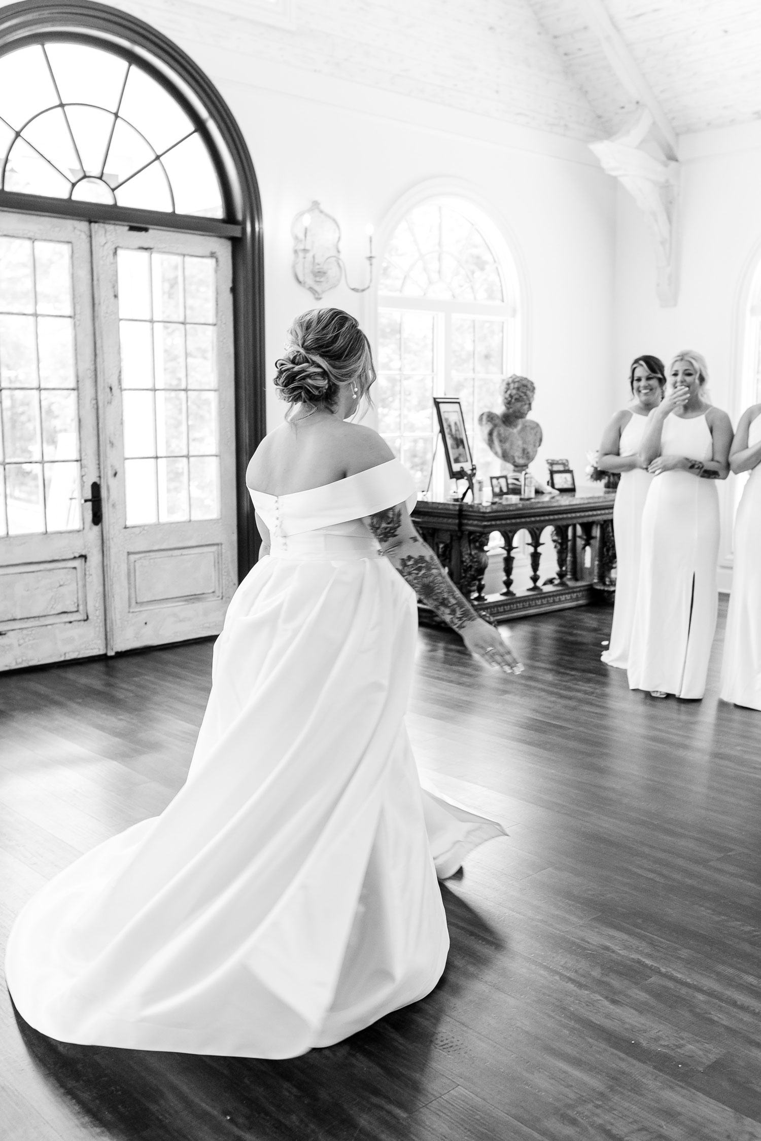 The bridesmaids see the bride for the first time in her wedding dress in Alabama.