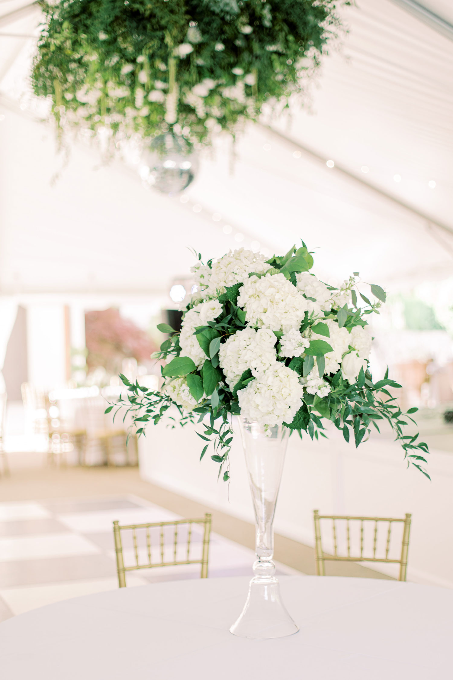 White flowers are arranged on the table for the Alabama wedding reception.