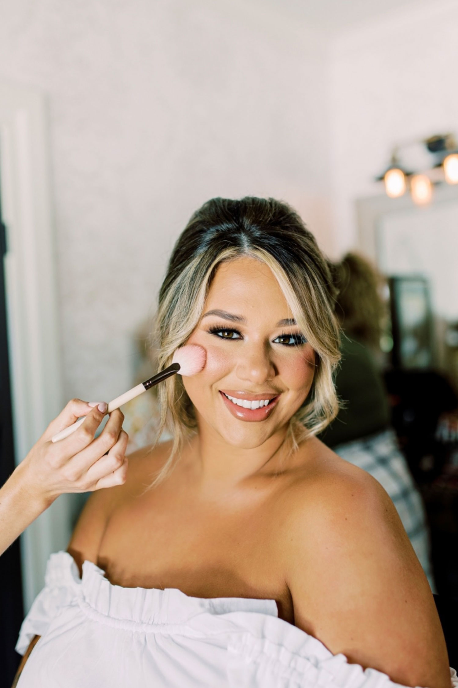 The makeup artist finishes the bridal makeup before the Alabama wedding ceremony.